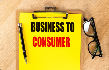 Clipboard with business to consumer text on yellow paper with black pen and eyeglasses