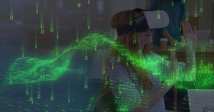 Reaching woman in casual T-shirt and VR headset exploring binary code overlay at desk, copy space
