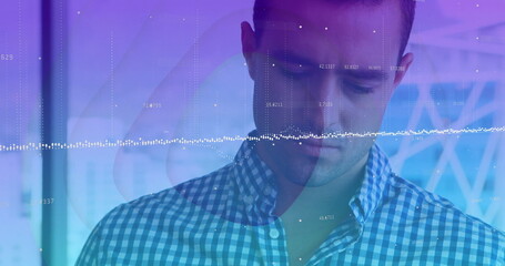 Data analyst in checkered shirt interpreting waveform overlay in tech lab, with numeric data points