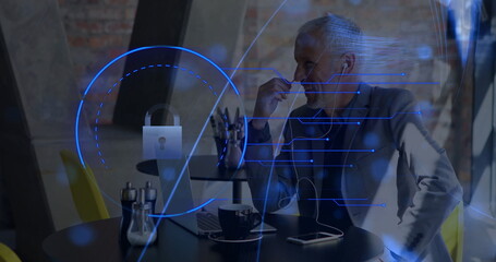Senior business professional analyzing cybersecurity data on laptop in cafe workspace, with coffee