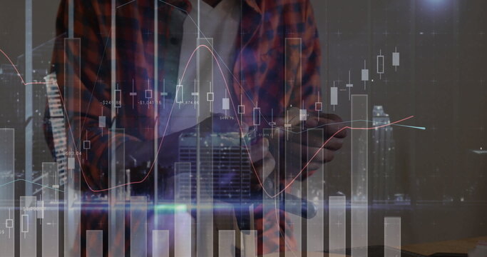 Holding tablet man wearing plaid shirt at wooden desk, with candlestick bars and trend lines - Powered by Adobe