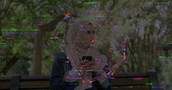 Sitting woman wearing hijab on bench in park holding smartphone, with network graph overlay