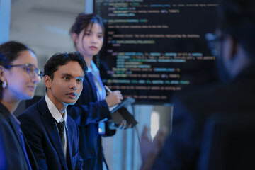 From behind, a manager or director watches a virtual team meeting on a large screen. A concept for modern leadership, global business strategy, data analysis, and remote collaboration.