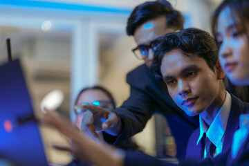 An Indian business manager leads his diverse team, analyzing critical market data on a screen. Intense focus on financial strategy and corporate decision making in a modern office.