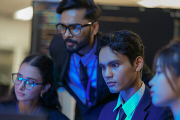 A senior AI architect mentors a diverse team as they debug a complex neural network. Intense, focused collaboration on developing the future of Artificial General Intelligence (AGI).