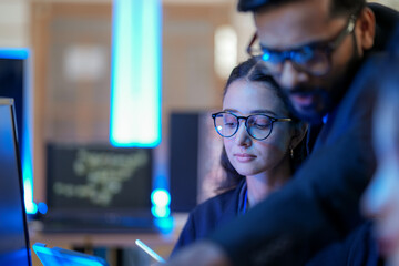 A senior AI architect mentors a diverse team as they debug a complex neural network. Intense, focused collaboration on developing the future of Artificial General Intelligence (AGI).