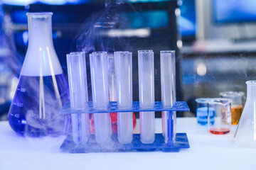 A focused scientist in full protective gear meticulously compares two different chemical solutions in beakers. A concept for pharmaceutical research, quality control, and analysis.