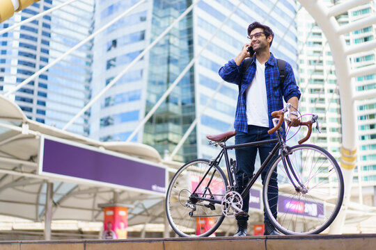 Asian man walking bicycle in city, commuting to work for fitness and eco-friendly lifestyle. - Powered by Adobe
