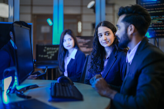 A diverse team of young AI engineers in a strategy meeting. Indian and East Asian colleagues discuss the next phase of development for a complex machine learning model in their lab. - Powered by Adobe