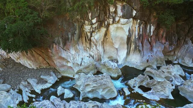 A sweeping side-view shot frames the riverside rock formations and surrounding nature, emphasizing texture and beauty at Tinipak River, Tanay, Rizal.