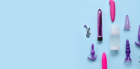 Bottle of lubricant and sex toys on blue background with space for text, top view