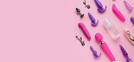 Many different sex toys and bottle of lubricant on pink background with space for text, top view