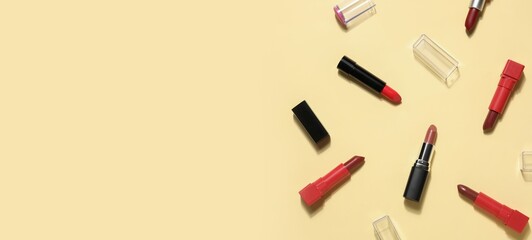 Many different lipsticks on beige background with space for text, top view