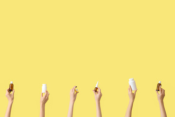 Female hands with pills, nasal sprays and ampule on yellow background