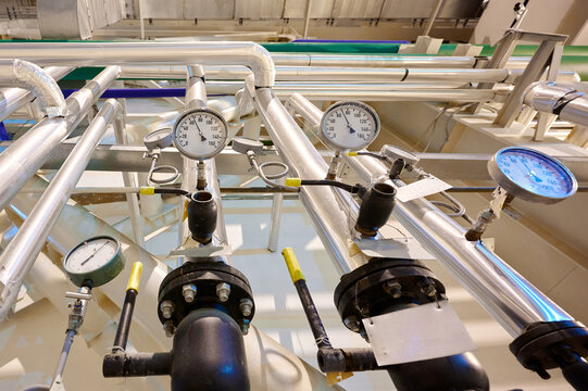 Thermometers and gauges on industrial equipment in a facility showcasing temperature monitoring processes