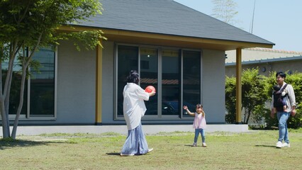 平屋の庭で遊ぶ家族