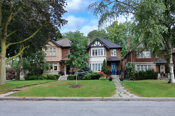 Residential street with older two story detached houses and large front yards