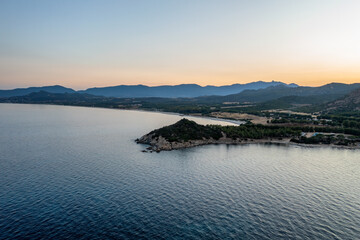 Aerial drone view of Capo Ferrato in the calm sea at sunset, wit