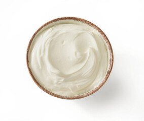 Sour cream or yogurt in white bowl isolated on white background. Top view.