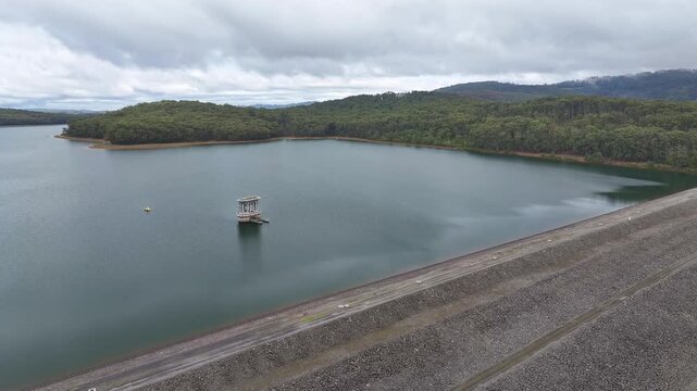 Silvan Reservoir dam edge and intake tower surrounded by forested banks and still water