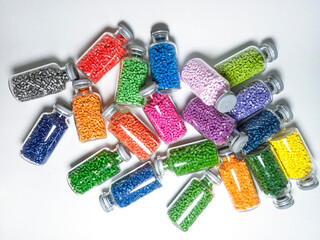 Top view, masterbatch granules in a glass cup, isolated on a white background, looks messy, giving an elegant design color, suitable as a product catalog design for industrial plastic company profiles