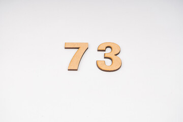 Number seventy-three on paper on a white background.