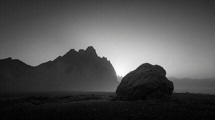 Black and white rock at sunrise, mountains in the distance