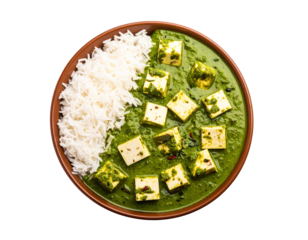 Topdown view of Indian Palak Paneer a green spinach curry with cheese cubes and steamed basmati rice served in a rustic brown bowl.