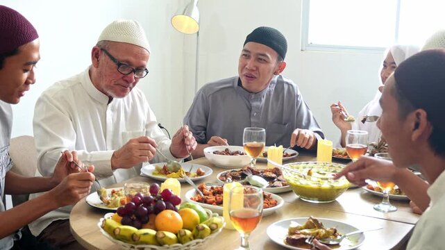 Family Of Muslim People Sharing Meal Together At Round Table During Eid Or Ramadan