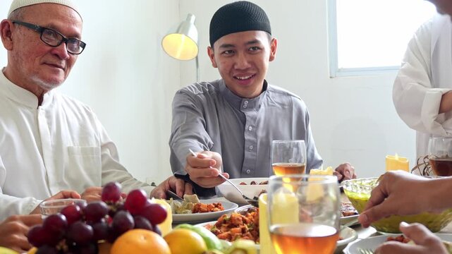 Portrait Of Multi Generation Muslim Family Eating Together During Eid Celebration Moment At Dining Room