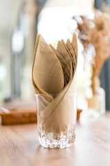 Brown tissue paper in glass on table
