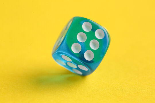 Blue game dice on yellow background