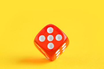 Red game dice on yellow background