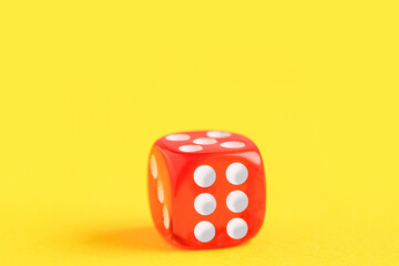 Red game dice on yellow background
