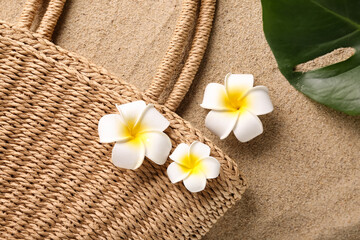Obraz na płótnie Canvas Plumeria flowers with bag on sand, closeup