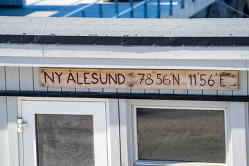 Sign with coordinates on the pier at the research station in Ny Alesund, Svalbard, Norway