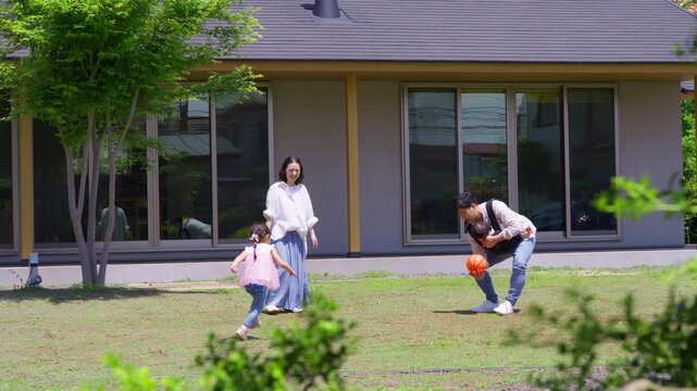 平屋の庭で遊ぶ家族