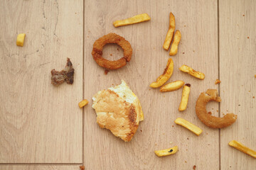 Food remnants scattered on wooden floor after meal