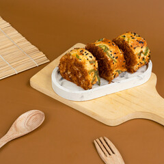 Three slices of bread roll topped with shredded meat floss, black sesame seeds, and green onion slices, served on a white marble-patterned tray over a wooden serving board with a brown background.