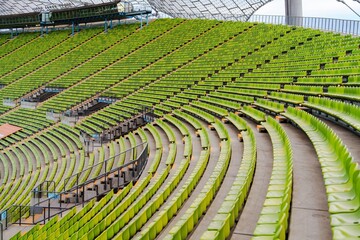 Fototapeta premium A large stadium featuring green seating, designed for sports events and concerts. Perfect for promotional materials and event planning concepts in entertainment venues.