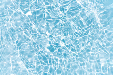 Blue water with ripples on the surface. Defocus blurred transparent blue colored clear calm water surface texture with splashes and bubbles. Water waves with shining pattern texture background.