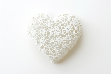 Fototapeta premium Delicate white crocheted heart casting a soft shadow on a clean