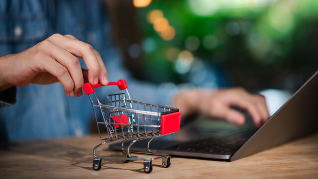 Mini shopping cart beside a laptop, representing e-commerce, online shopping, and digital retail business for modern consumers and global marketplace connectivity ,online business, convenience.