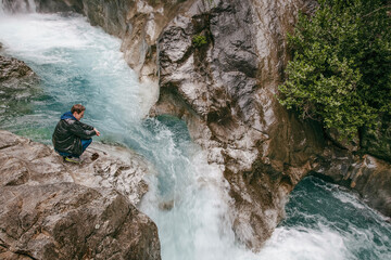 A man stands on the edge of a cliff above a waterfall in Sapadere Kanyonu, Sapadere, Antalya Province, Turkey © Anna Kapustina