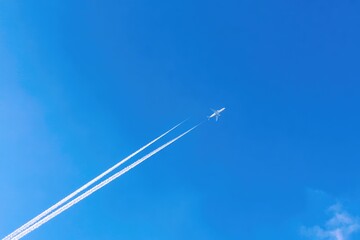 Airplane trails across vibrant blue sky