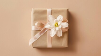 Beautifully wrapped gift with floral decoration on smooth beige background ready for celebration or special occasion