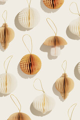 Minimal trend pattern of Festive Paper Christmas Ornaments, vivid beige New Year decorations, honeycomb scandinavian decor on light background, neutral colored monochrome photo, happy holidays layout