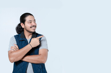 Smiling man pointing to copy space on isolated background. Young adult pointing to copy space on white background