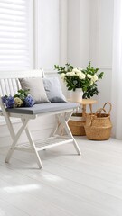 White bench with cushions, flowers, and baskets in a bright room