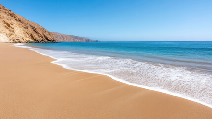 Fototapeta premium Serene sandy beach with gentle waves lapping at shore, surrounded by hills and clear blue skies